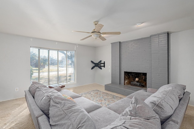 living room with a brick fireplace, carpet, and ceiling fan