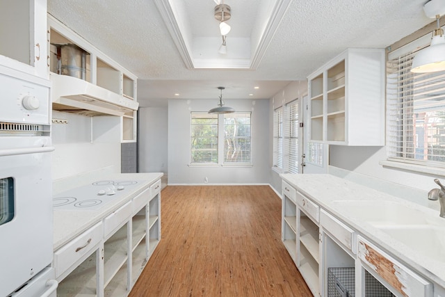 kitchen with a textured ceiling, white appliances, a sink, light wood-type flooring, and open shelves