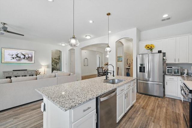 kitchen with visible vents, stainless steel appliances, a sink, and open floor plan