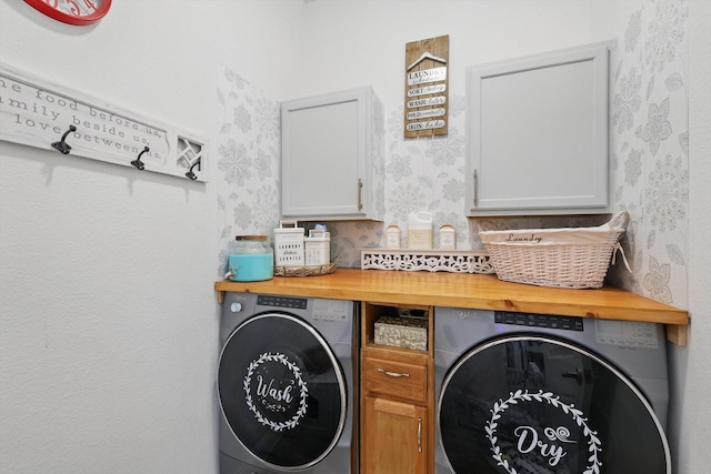 washroom featuring cabinet space and wallpapered walls