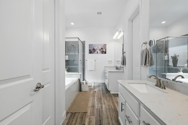 bathroom featuring a sink, a shower stall, and wood finished floors