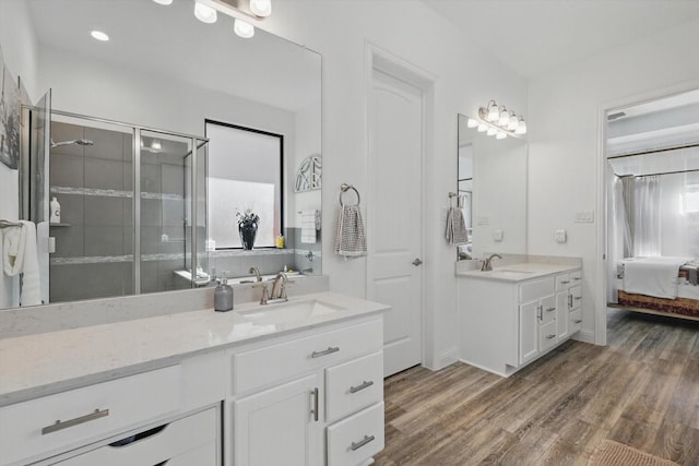 bathroom with a sink, a shower stall, and wood finished floors