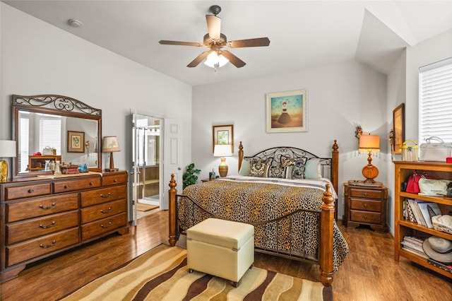 bedroom featuring multiple windows, ceiling fan, ensuite bathroom, and wood finished floors