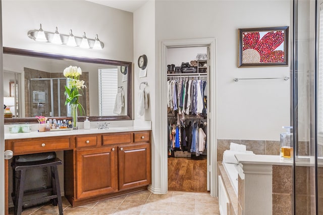 bathroom featuring a bathtub, a spacious closet, a shower stall, vanity, and tile patterned flooring