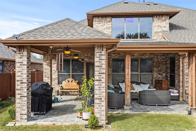 back of property featuring brick siding, a patio, an outdoor hangout area, and roof with shingles