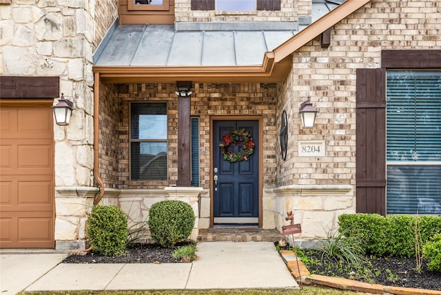 doorway to property featuring stone siding, metal roof, and a standing seam roof