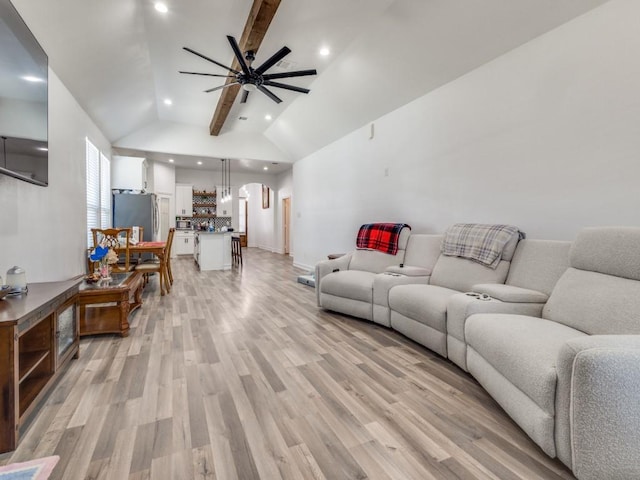 living room featuring ceiling fan, arched walkways, recessed lighting, light wood-type flooring, and beam ceiling