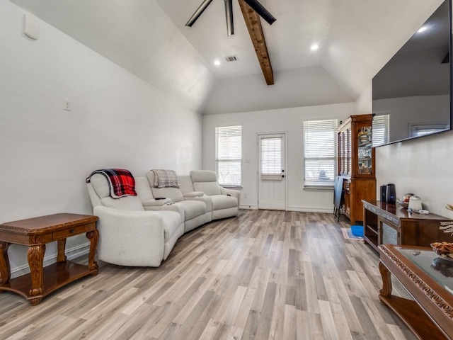 living room featuring light wood-type flooring, visible vents, and lofted ceiling with beams