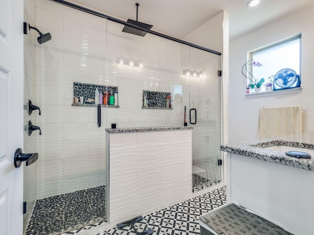 bathroom with a stall shower, vanity, and tile patterned floors