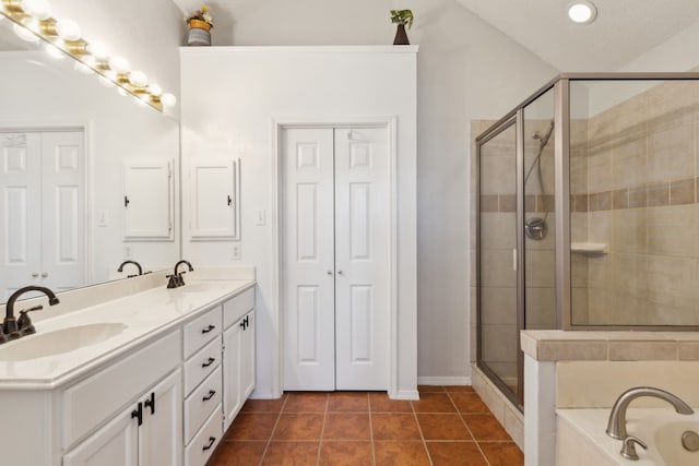 bathroom featuring double vanity, a stall shower, a sink, and tile patterned floors