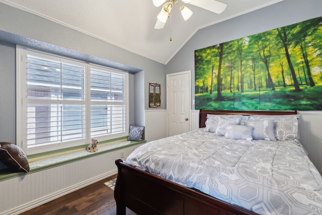 bedroom with lofted ceiling, a wainscoted wall, dark wood finished floors, and a ceiling fan