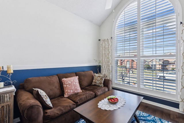 living area with vaulted ceiling, a textured ceiling, and wood finished floors