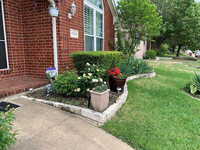 exterior space with a yard and brick siding