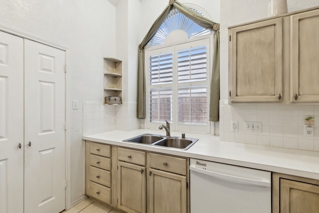 kitchen featuring light brown cabinetry, white dishwasher, a sink, and light countertops