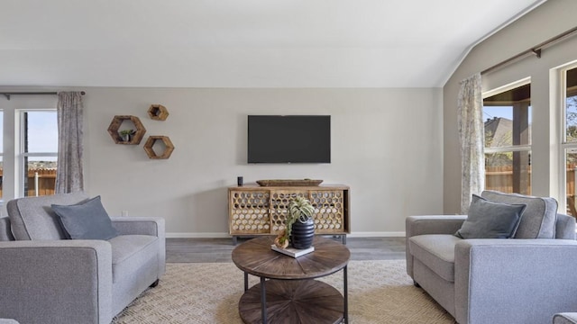 living room with lofted ceiling, baseboards, and wood finished floors