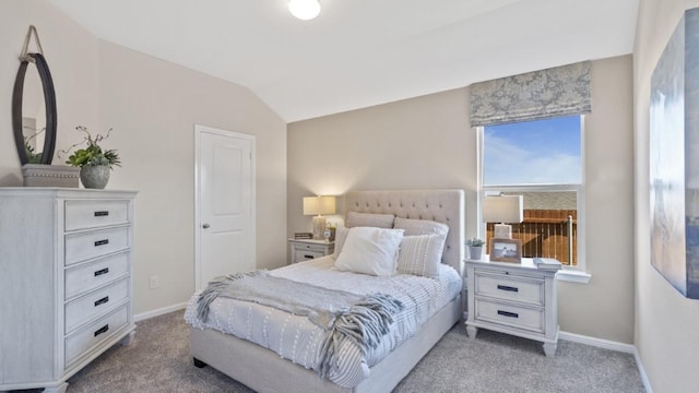 carpeted bedroom with vaulted ceiling and baseboards