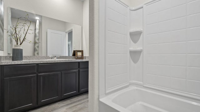 full bath featuring vanity, wood finished floors, and shower / bathtub combination