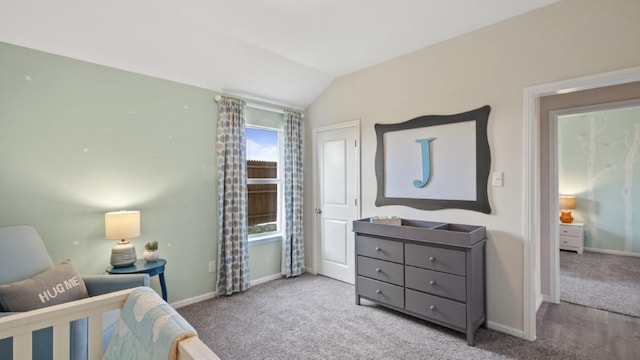 bedroom with a crib, baseboards, vaulted ceiling, and carpet flooring