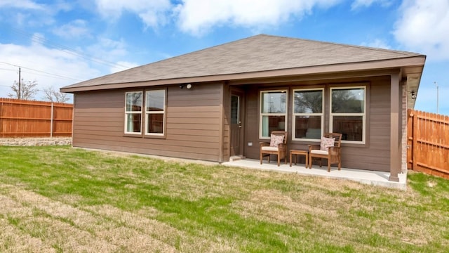 rear view of property with a yard, a patio area, and fence