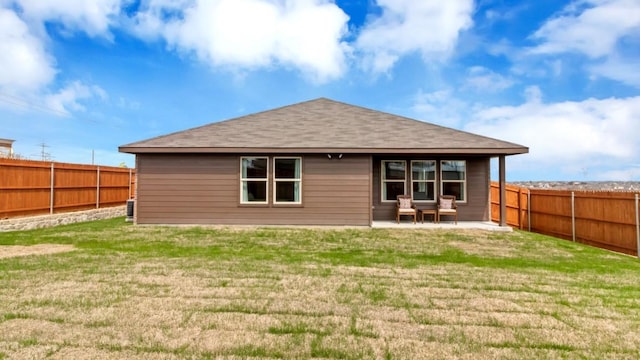 back of house featuring a yard, a patio area, and a fenced backyard