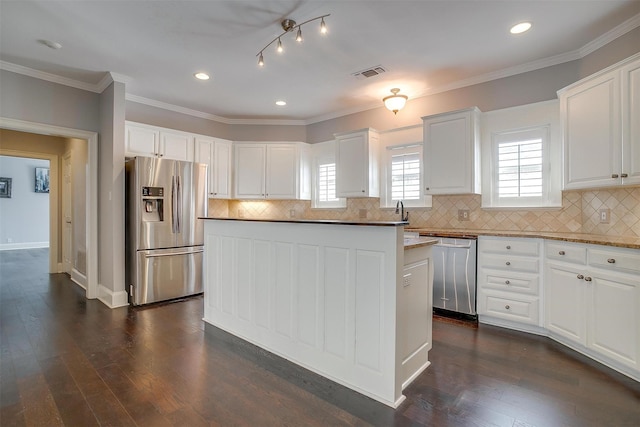 kitchen with ornamental molding, appliances with stainless steel finishes, dark wood finished floors, and visible vents