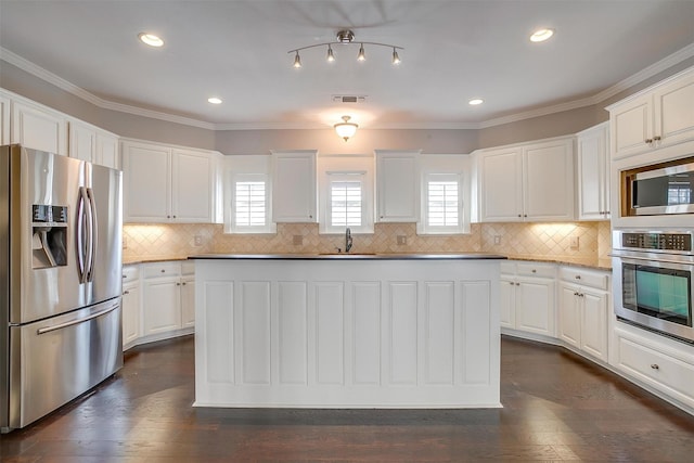 kitchen with appliances with stainless steel finishes, white cabinetry, a sink, and dark wood-style floors