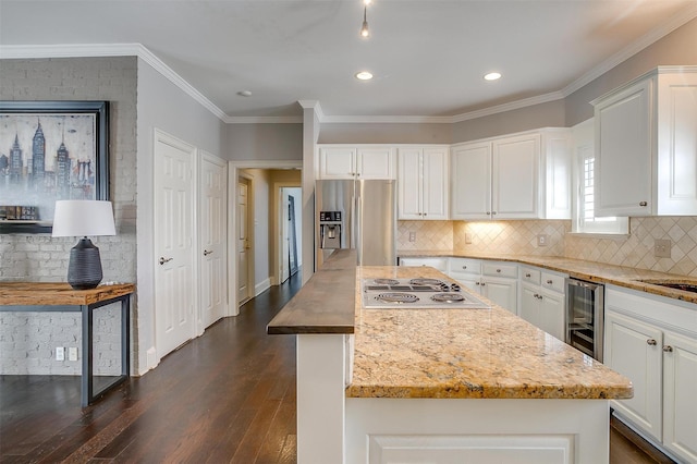 kitchen featuring appliances with stainless steel finishes, beverage cooler, white cabinets, and dark wood-style flooring