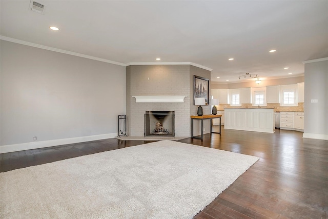 living area with baseboards, visible vents, dark wood-style flooring, and ornamental molding