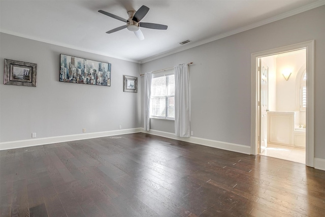 spare room featuring dark wood-style flooring, visible vents, ornamental molding, ceiling fan, and baseboards