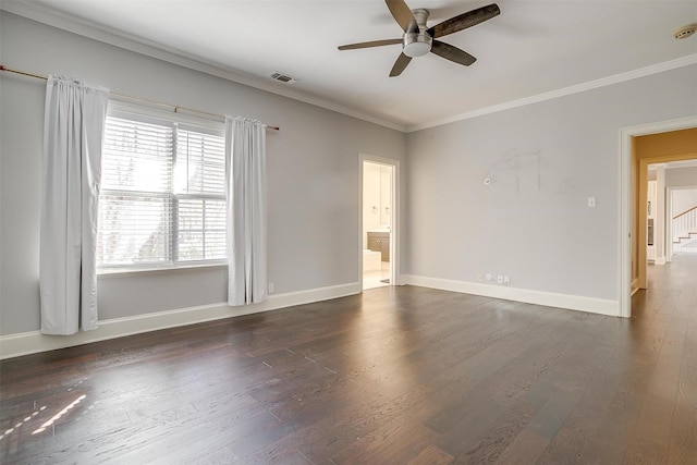 empty room with ornamental molding, dark wood-style flooring, visible vents, and baseboards