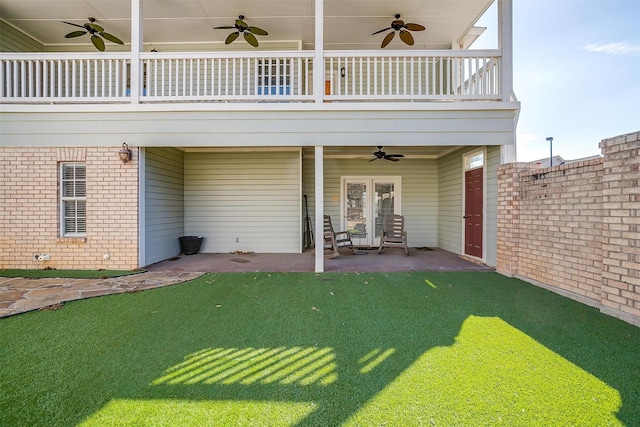 exterior space featuring french doors, brick siding, a patio, ceiling fan, and a balcony