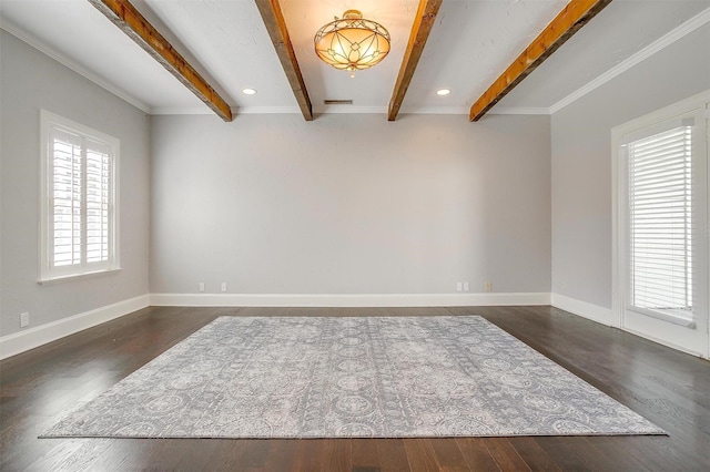 spare room with beam ceiling, baseboards, and wood finished floors