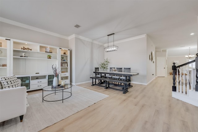 interior space with visible vents, a chandelier, light wood-style flooring, and ornamental molding