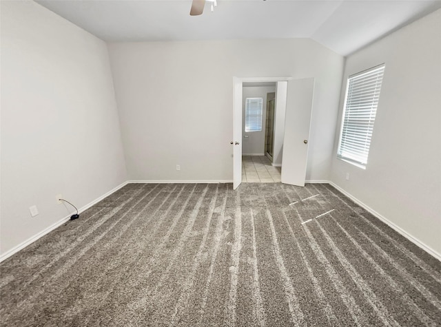 unfurnished room featuring vaulted ceiling, carpet floors, ceiling fan, and baseboards