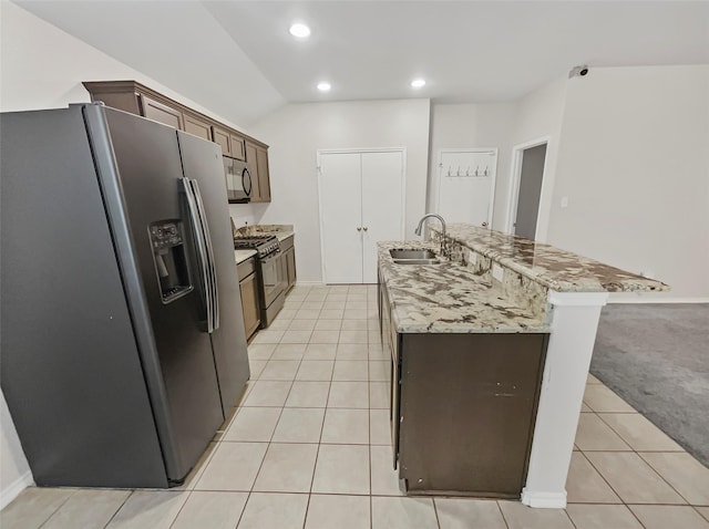 kitchen with light tile patterned floors, recessed lighting, stainless steel appliances, a sink, and an island with sink