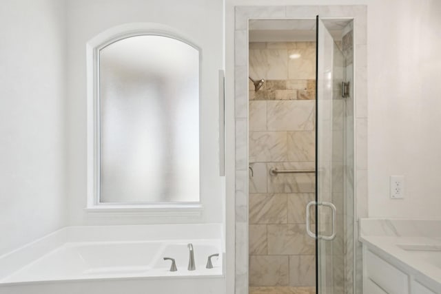 bathroom with a garden tub, a shower stall, and vanity