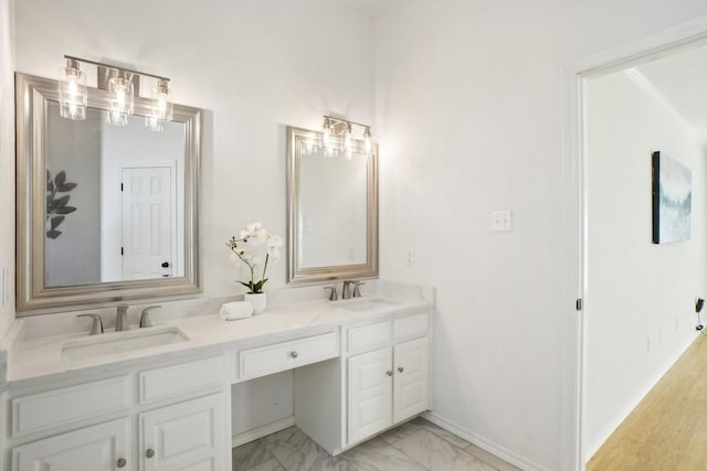 bathroom featuring marble finish floor, a sink, baseboards, and double vanity