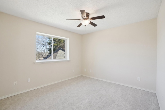 empty room featuring carpet floors, baseboards, a ceiling fan, and a textured ceiling