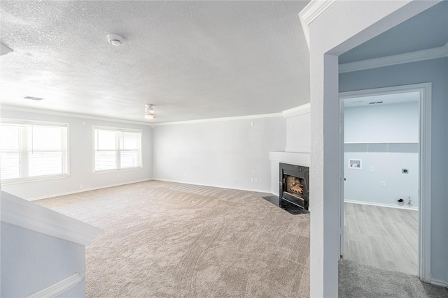 living room with carpet flooring, crown molding, a textured ceiling, and a premium fireplace