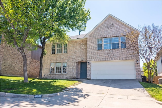 traditional-style house featuring an attached garage, a front yard, concrete driveway, and brick siding