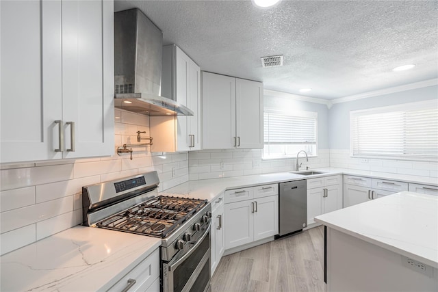 6512 Willow Oak Ct, Fort Worth, TX 76112 - kitchen featuring wall chimney range hood, appliances with stainless steel finishes, a sink, a textured ceiling, and visible vents