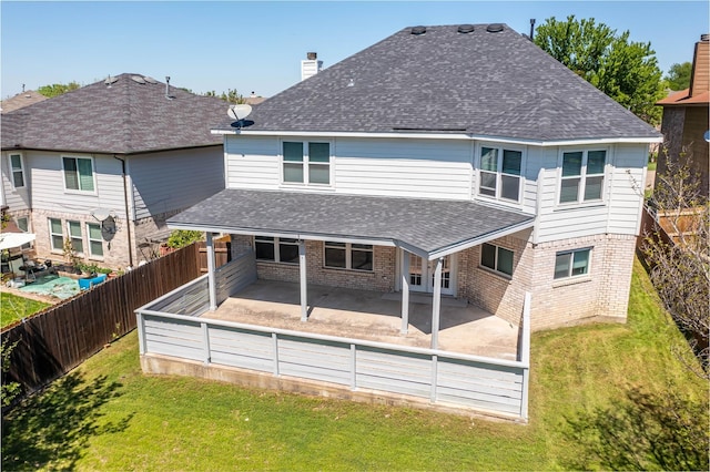 rear view of property with brick siding, a lawn, and roof with shingles