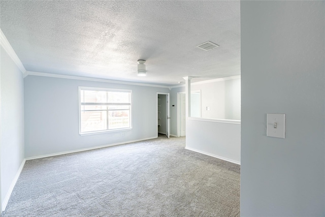 carpeted spare room with decorative columns, visible vents, baseboards, ornamental molding, and a textured ceiling