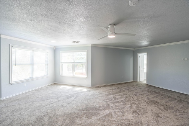 carpeted empty room featuring baseboards, visible vents, a ceiling fan, and ornamental molding