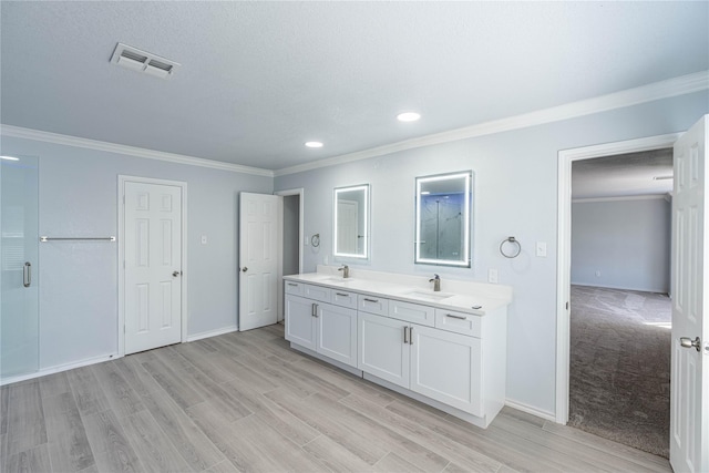 full bath featuring baseboards, visible vents, wood finished floors, crown molding, and a sink