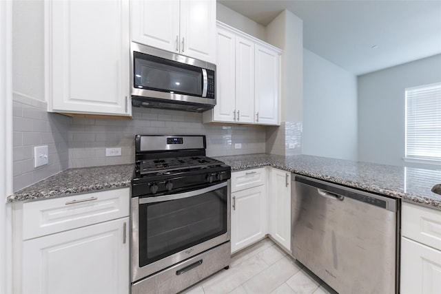 kitchen with decorative backsplash, appliances with stainless steel finishes, stone countertops, white cabinetry, and light tile patterned flooring