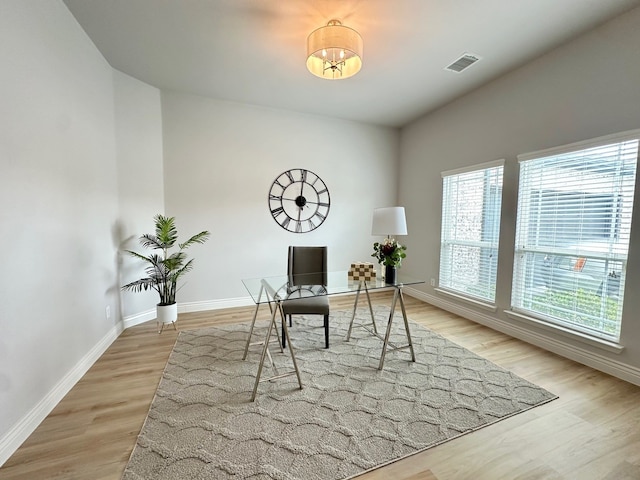 home office featuring light wood finished floors, visible vents, and baseboards