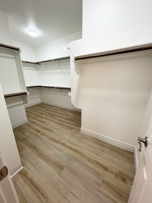 walk in closet with wood finished floors