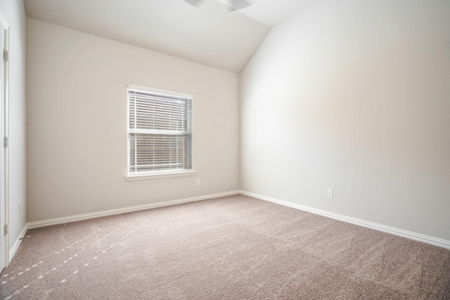 unfurnished room featuring carpet, baseboards, and vaulted ceiling