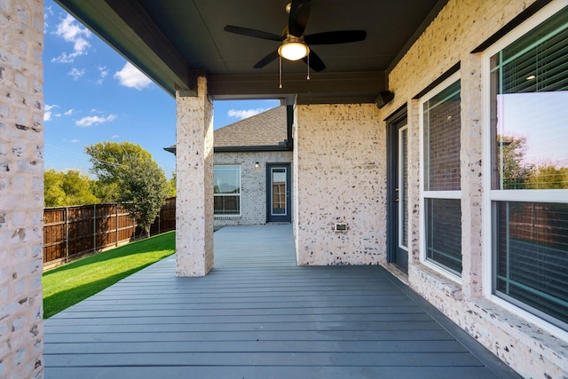 wooden deck with ceiling fan and fence